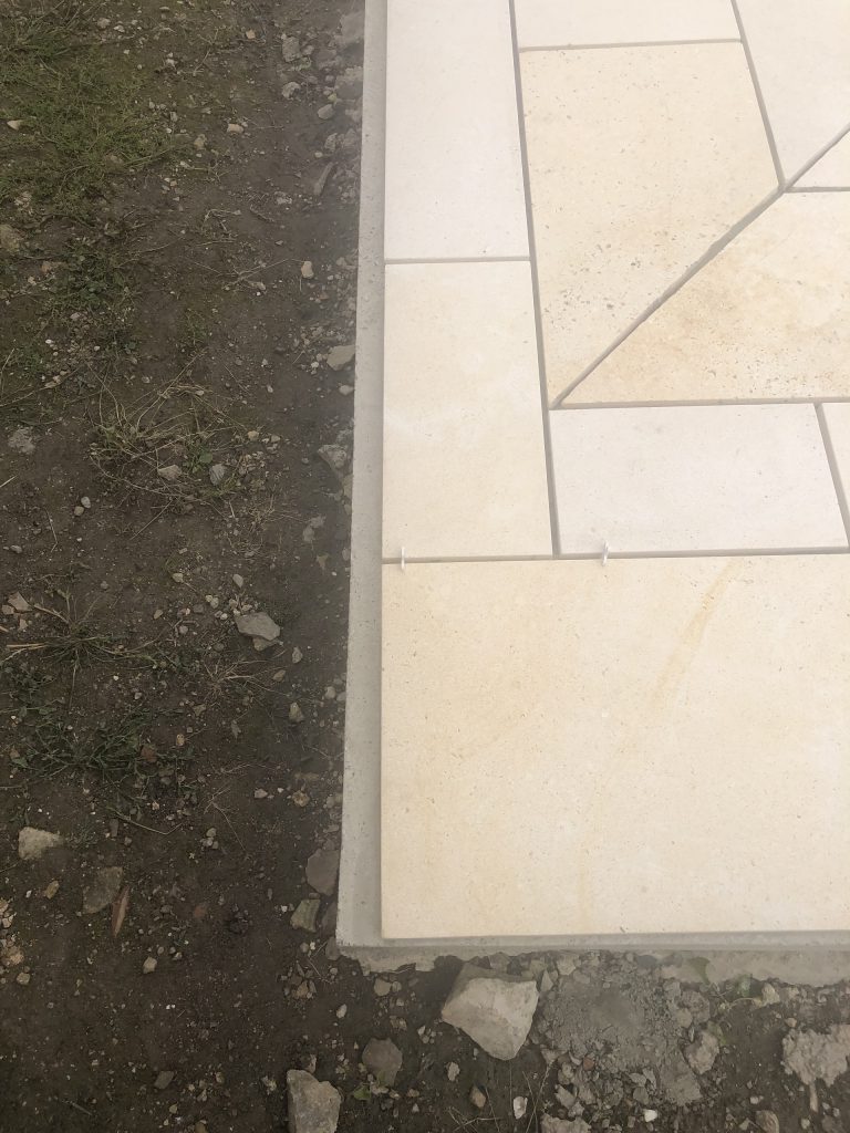 Pose des margelles et dallage en pierre autour d'une piscine à MARANS