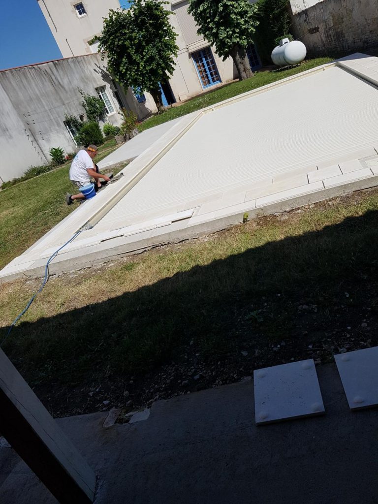 Pose des margelles et dallage en pierre autour d'une piscine à MARANS