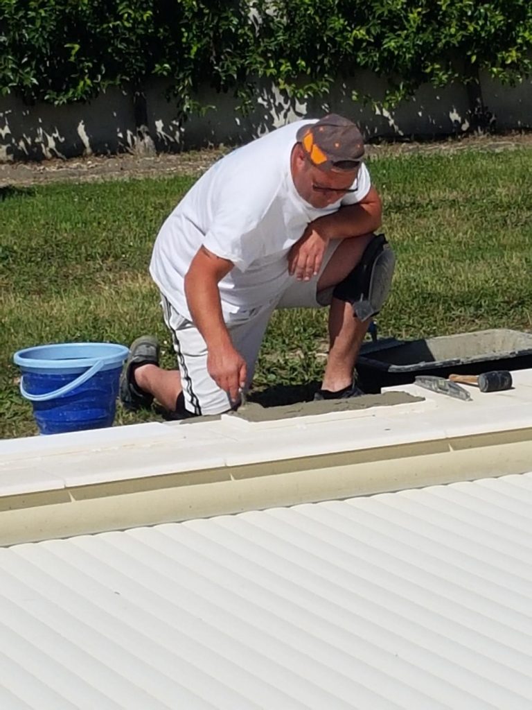 Pose des margelles et dallage en pierre autour d'une piscine à MARANS