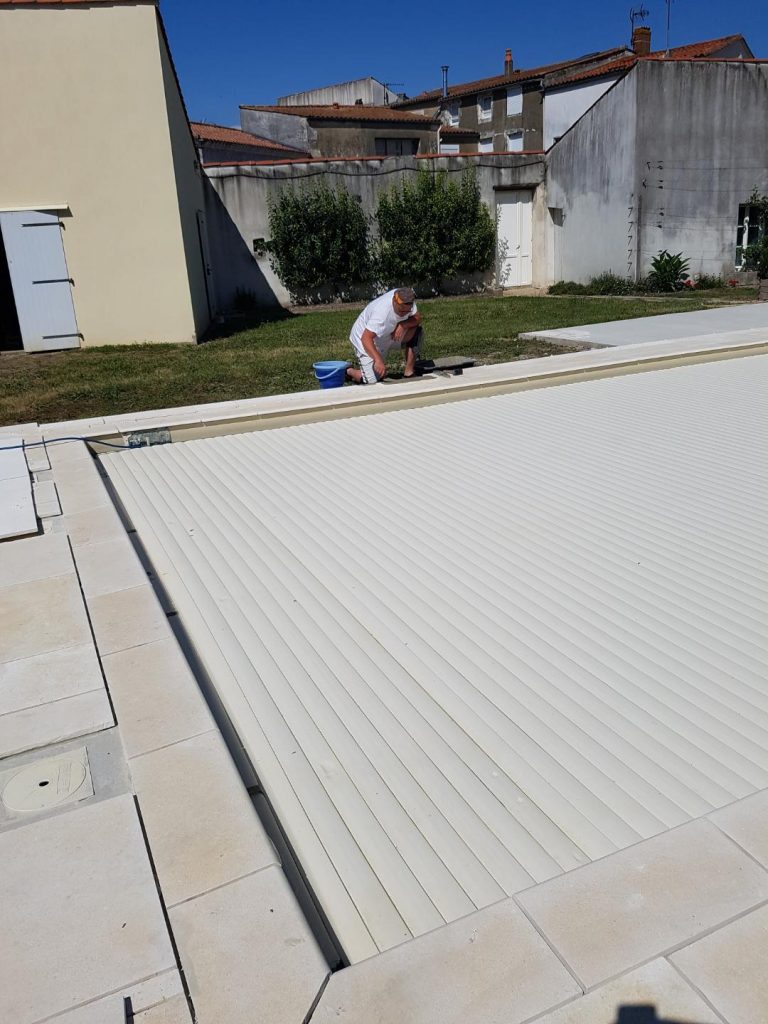 Pose des margelles et dallage en pierre autour d'une piscine à MARANS