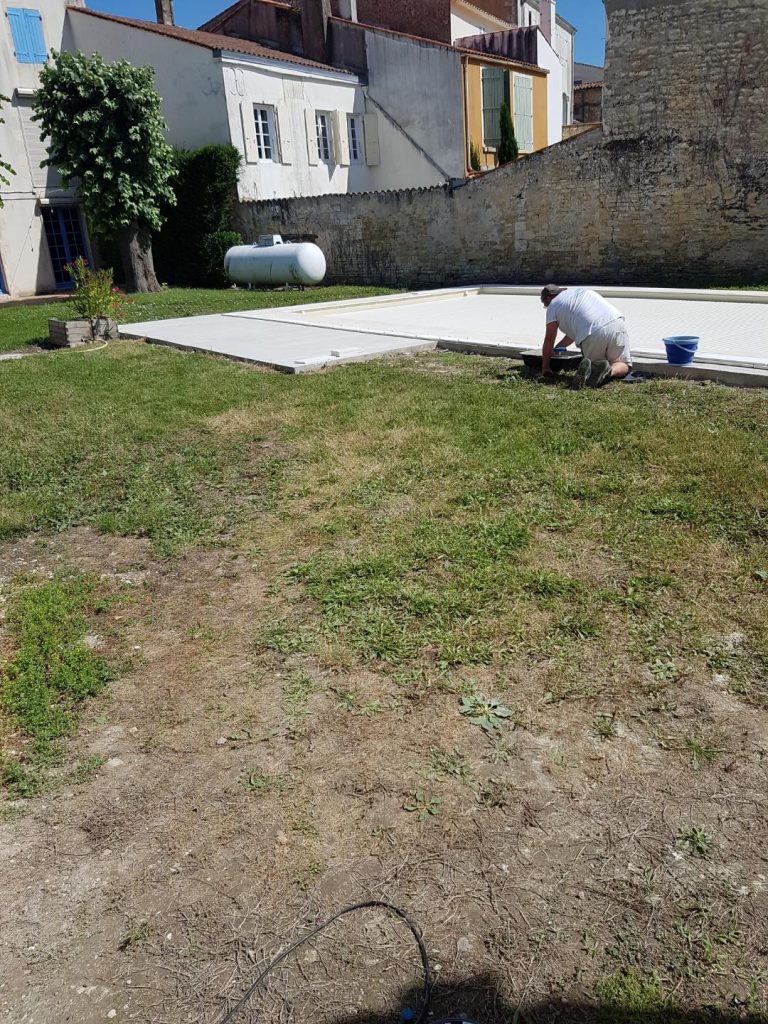 Pose des margelles et dallage en pierre autour d'une piscine à MARANS