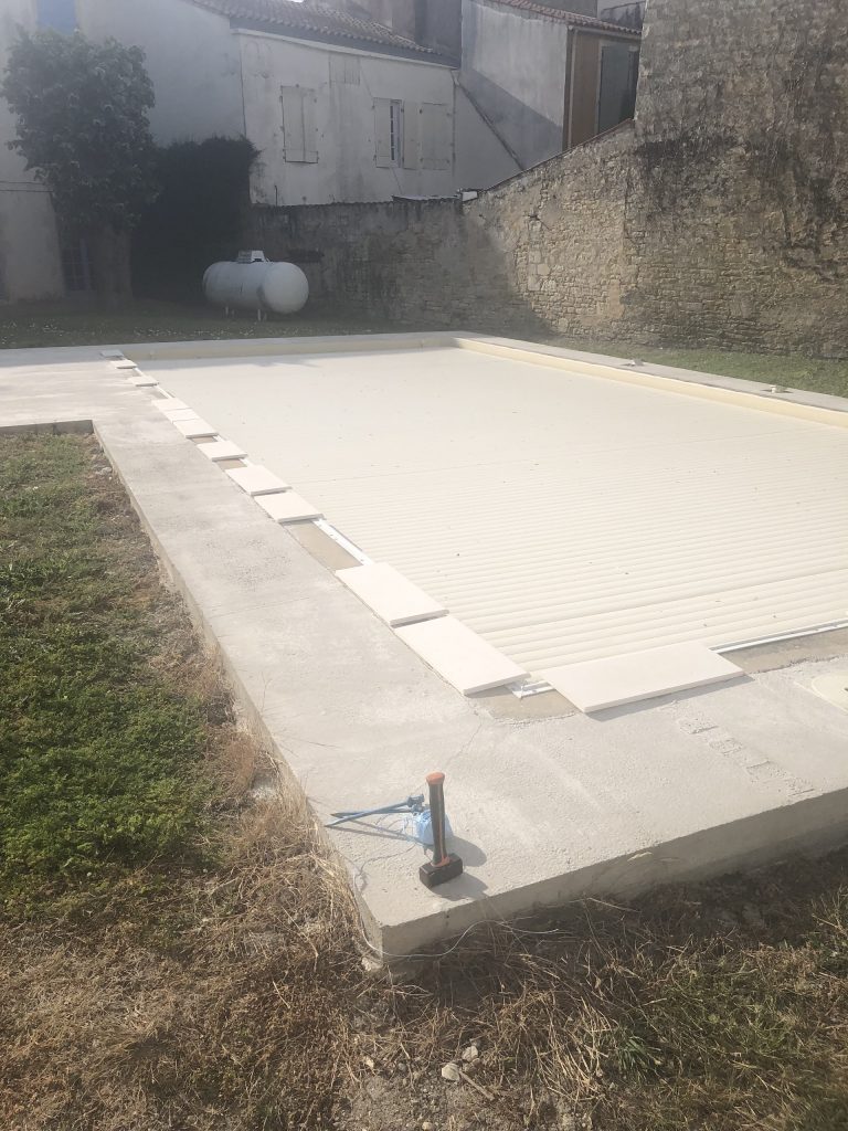 Pose des margelles et dallage en pierre autour d'une piscine à MARANS