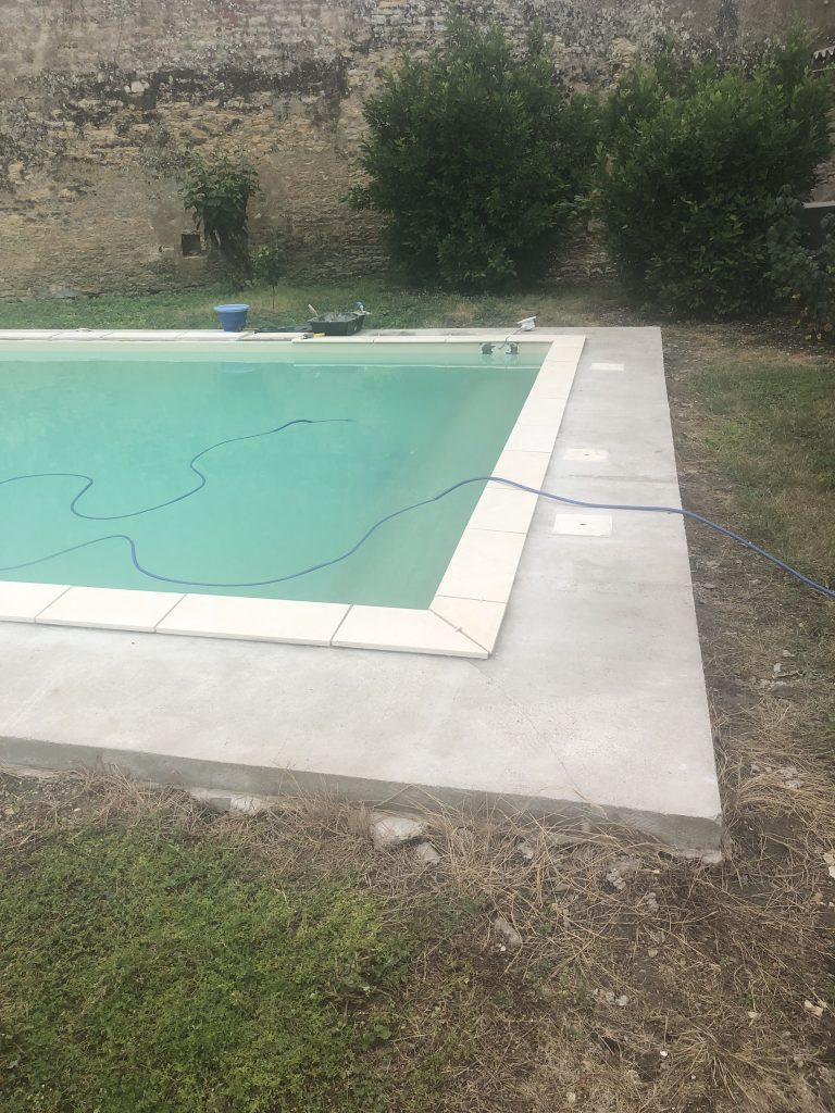 Pose des margelles et dallage en pierre autour d'une piscine à MARANS