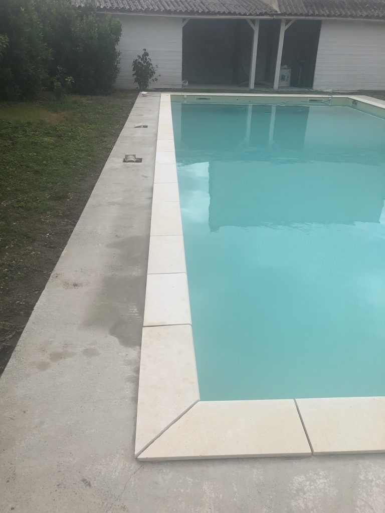 Pose des margelles et dallage en pierre autour d'une piscine à MARANS