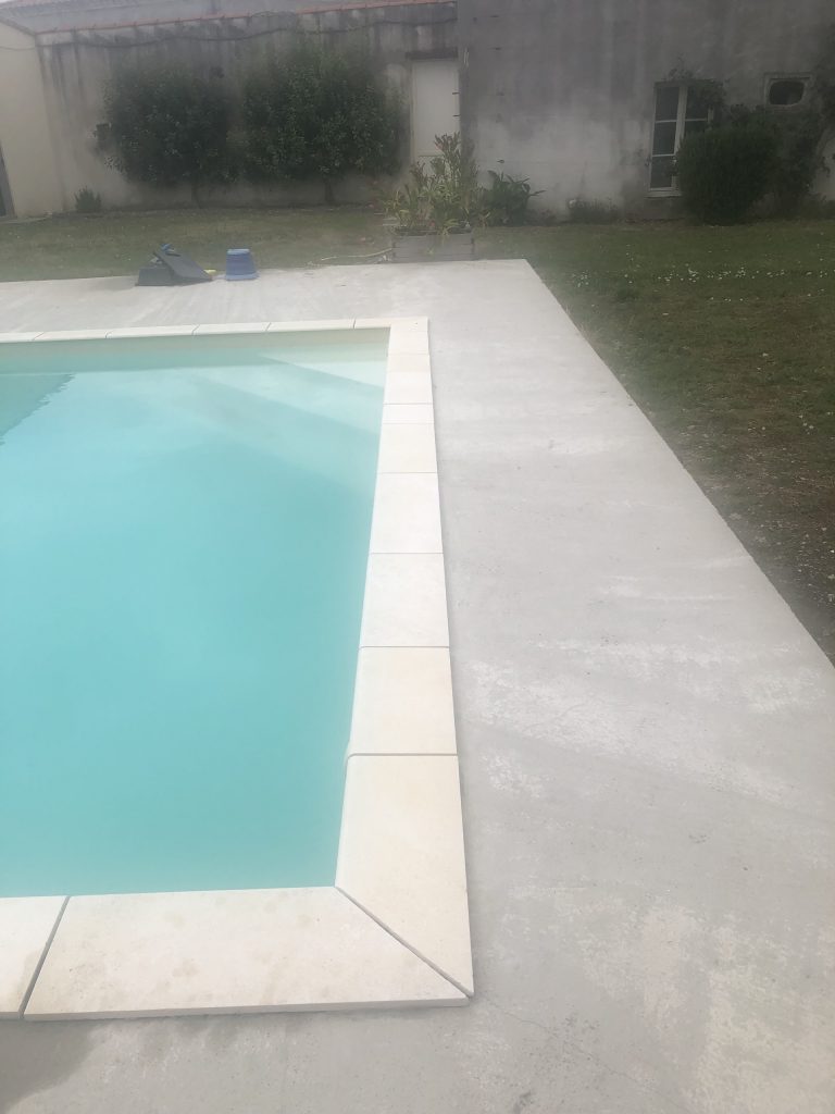 Pose des margelles et dallage en pierre autour d'une piscine à MARANS