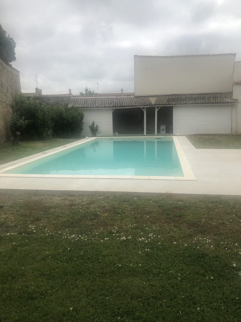 Pose des margelles et dallage en pierre autour d'une piscine à MARANS