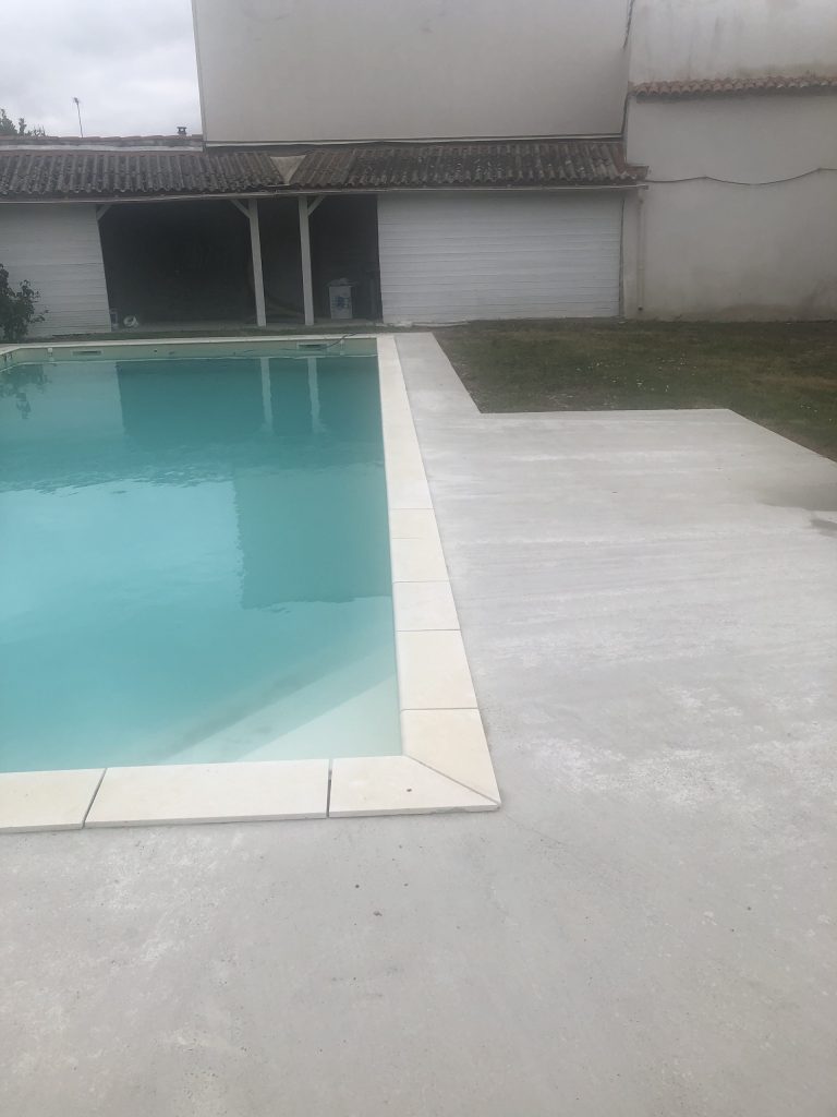 Pose des margelles et dallage en pierre autour d'une piscine à MARANS