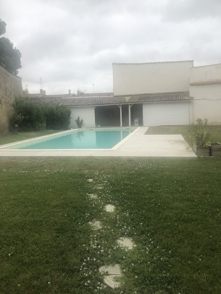 Pose des margelles et dallage en pierre autour d'une piscine à MARANS