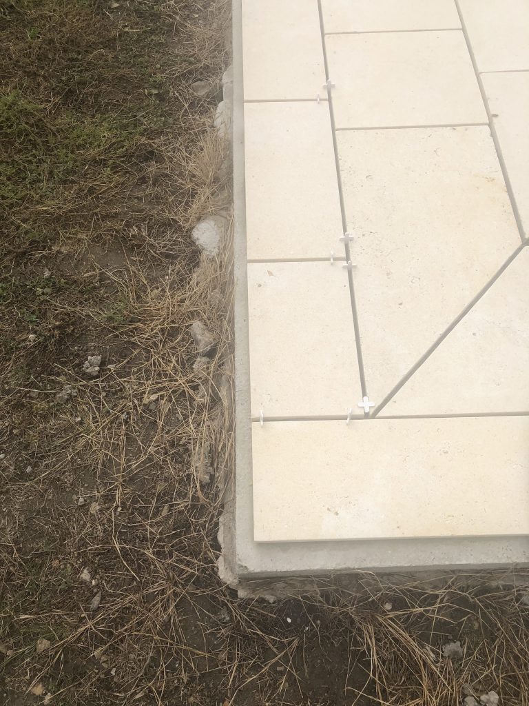 Pose des margelles et dallage en pierre autour d'une piscine à MARANS