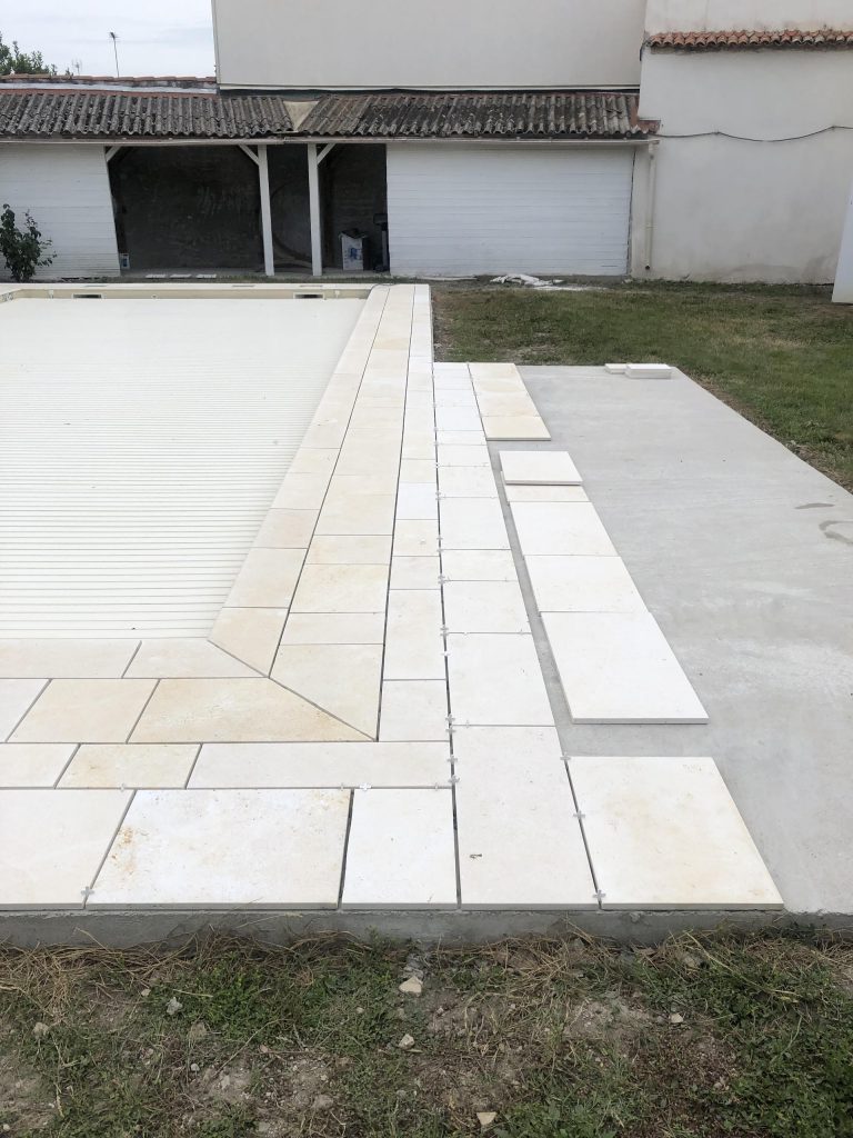 Pose des margelles et dallage en pierre autour d'une piscine à MARANS