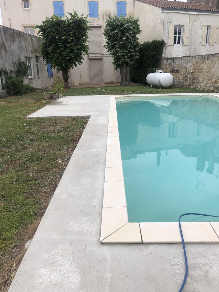Pose des margelles et dallage en pierre autour d'une piscine à MARANS