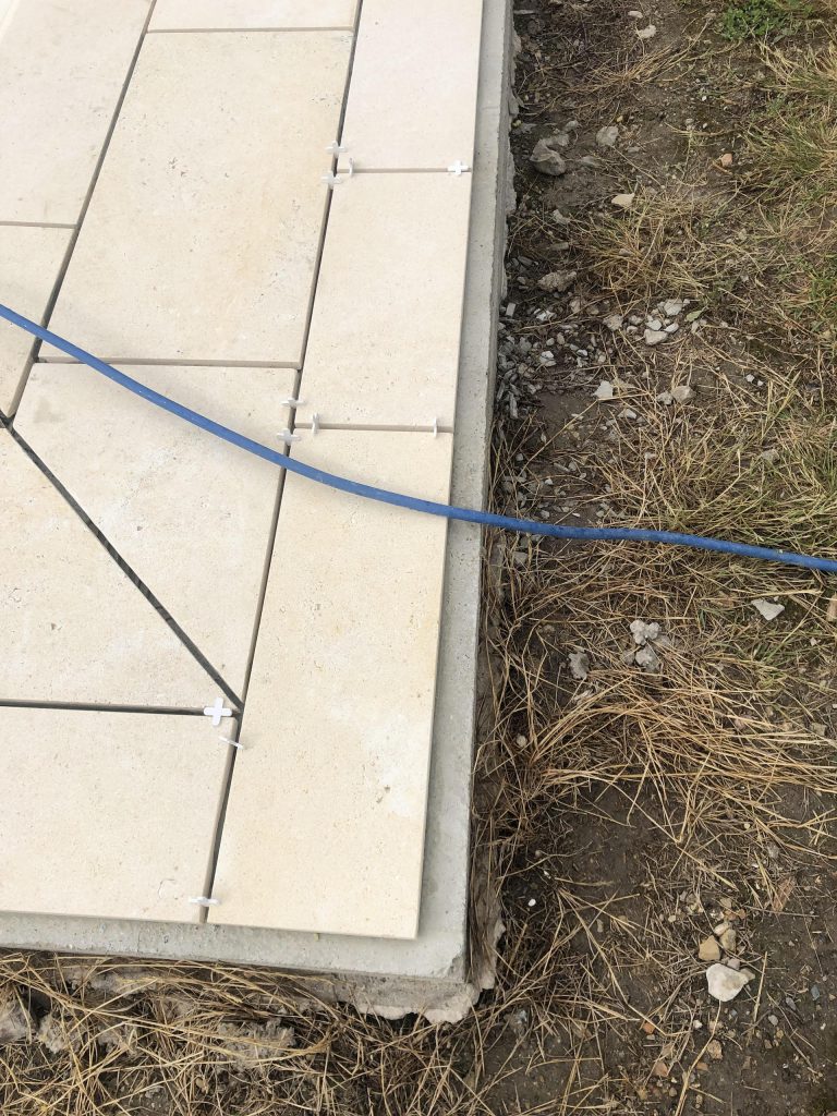 Pose des margelles et dallage en pierre autour d'une piscine à MARANS