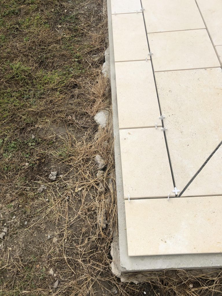 Pose des margelles et dallage en pierre autour d'une piscine à MARANS