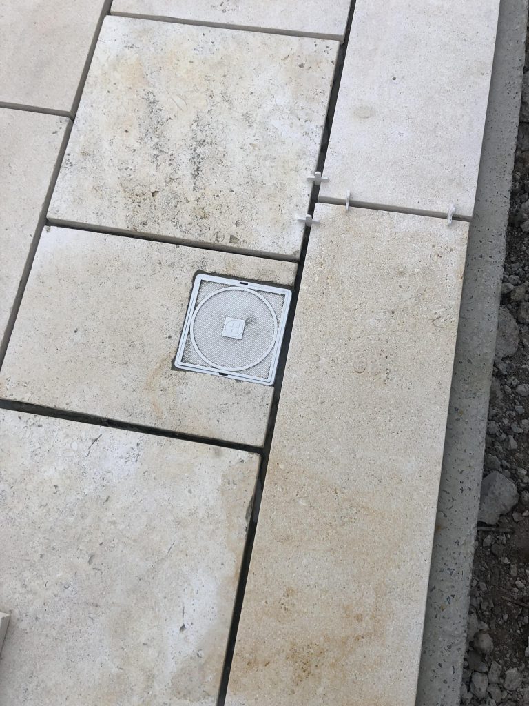 Pose des margelles et dallage en pierre autour d'une piscine à MARANS