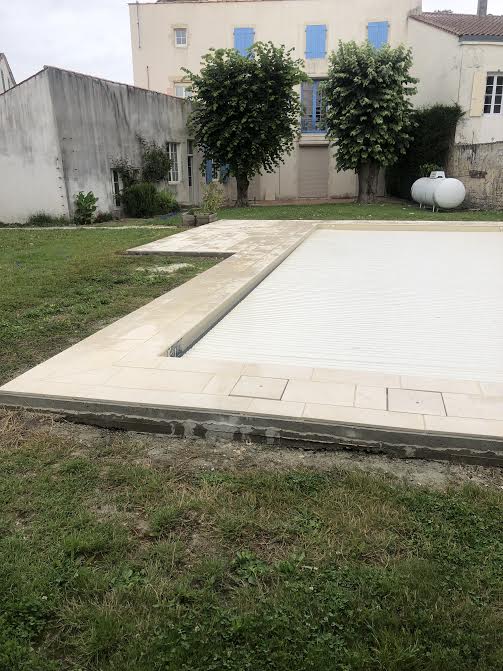 Pose des margelles et dallage en pierre autour d'une piscine à MARANS