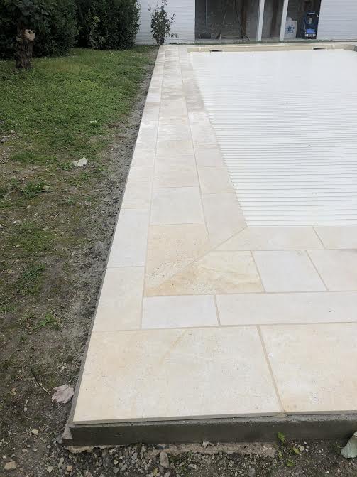 Pose des margelles et dallage en pierre autour d'une piscine à MARANS