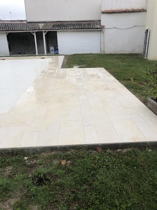 Pose des margelles et dallage en pierre autour d'une piscine à MARANS