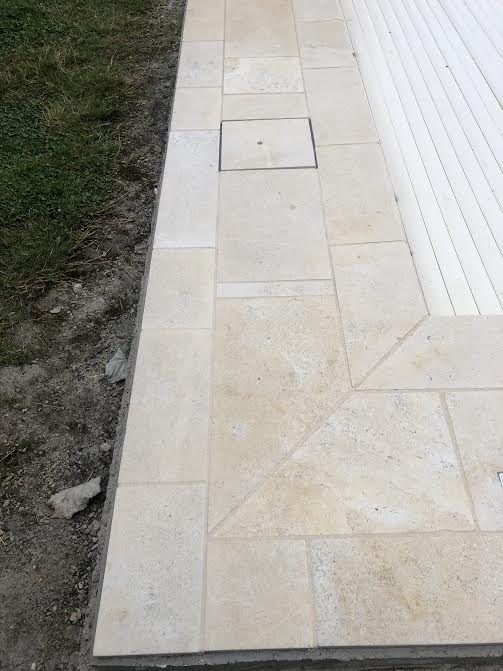 Pose des margelles et dallage en pierre autour d'une piscine à MARANS