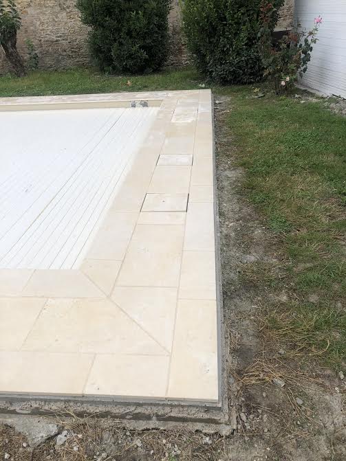 Pose des margelles et dallage en pierre autour d'une piscine à MARANS