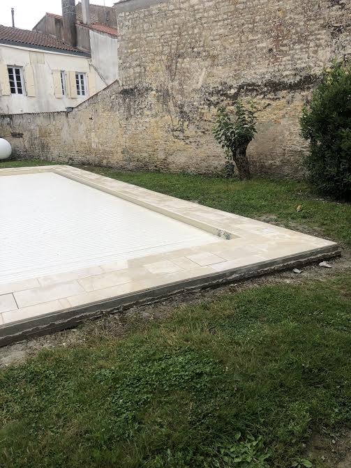 Pose des margelles et dallage en pierre autour d'une piscine à MARANS