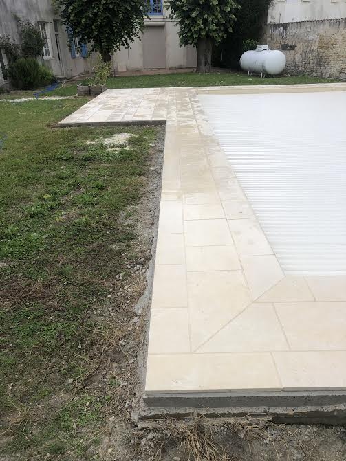 Pose des margelles et dallage en pierre autour d'une piscine à MARANS