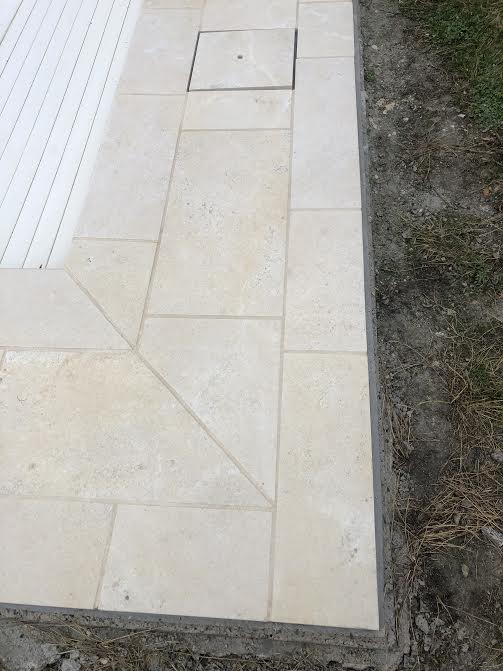 Pose des margelles et dallage en pierre autour d'une piscine à MARANS