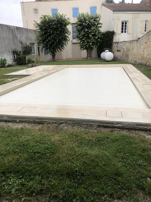 Pose des margelles et dallage en pierre autour d'une piscine à MARANS