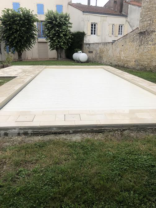 Pose des margelles et dallage en pierre autour d'une piscine à MARANS