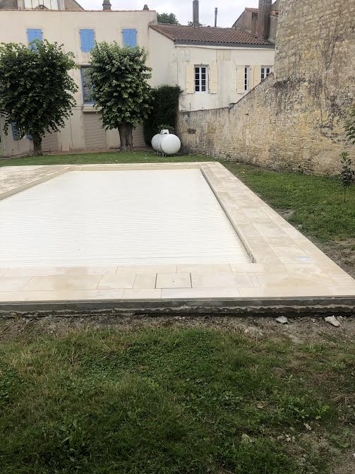 Pose des margelles et dallage en pierre autour d'une piscine à MARANS