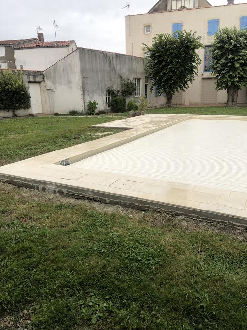Pose des margelles et dallage en pierre autour d'une piscine à MARANS