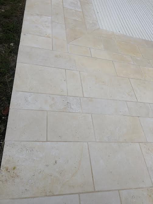 Pose des margelles et dallage en pierre autour d'une piscine à MARANS