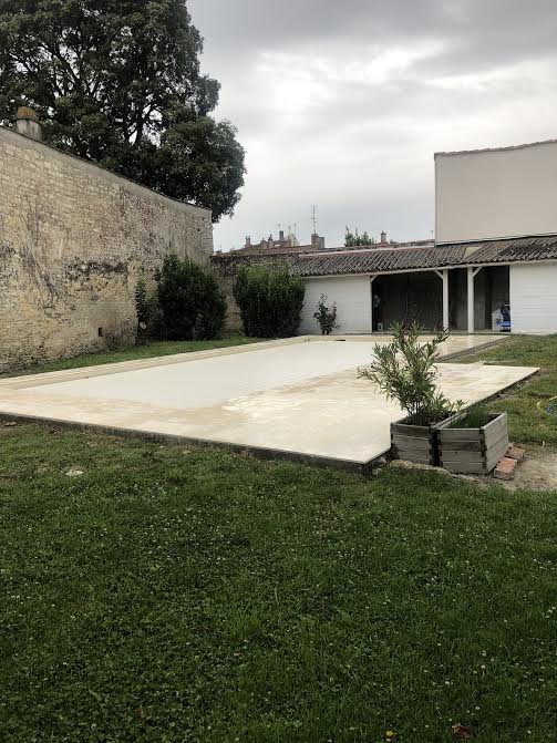 Pose des margelles et dallage en pierre autour d'une piscine à MARANS