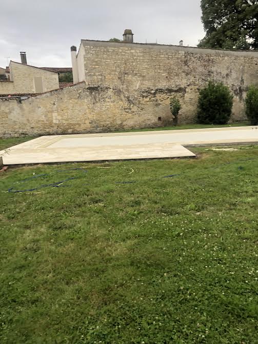 Pose des margelles et dallage en pierre autour d'une piscine à MARANS