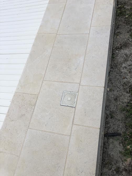 Pose des margelles et dallage en pierre autour d'une piscine à MARANS