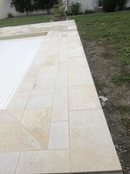 Pose des margelles et dallage en pierre autour d'une piscine à MARANS