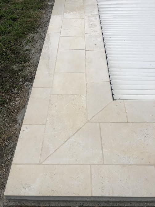 Pose des margelles et dallage en pierre autour d'une piscine à MARANS